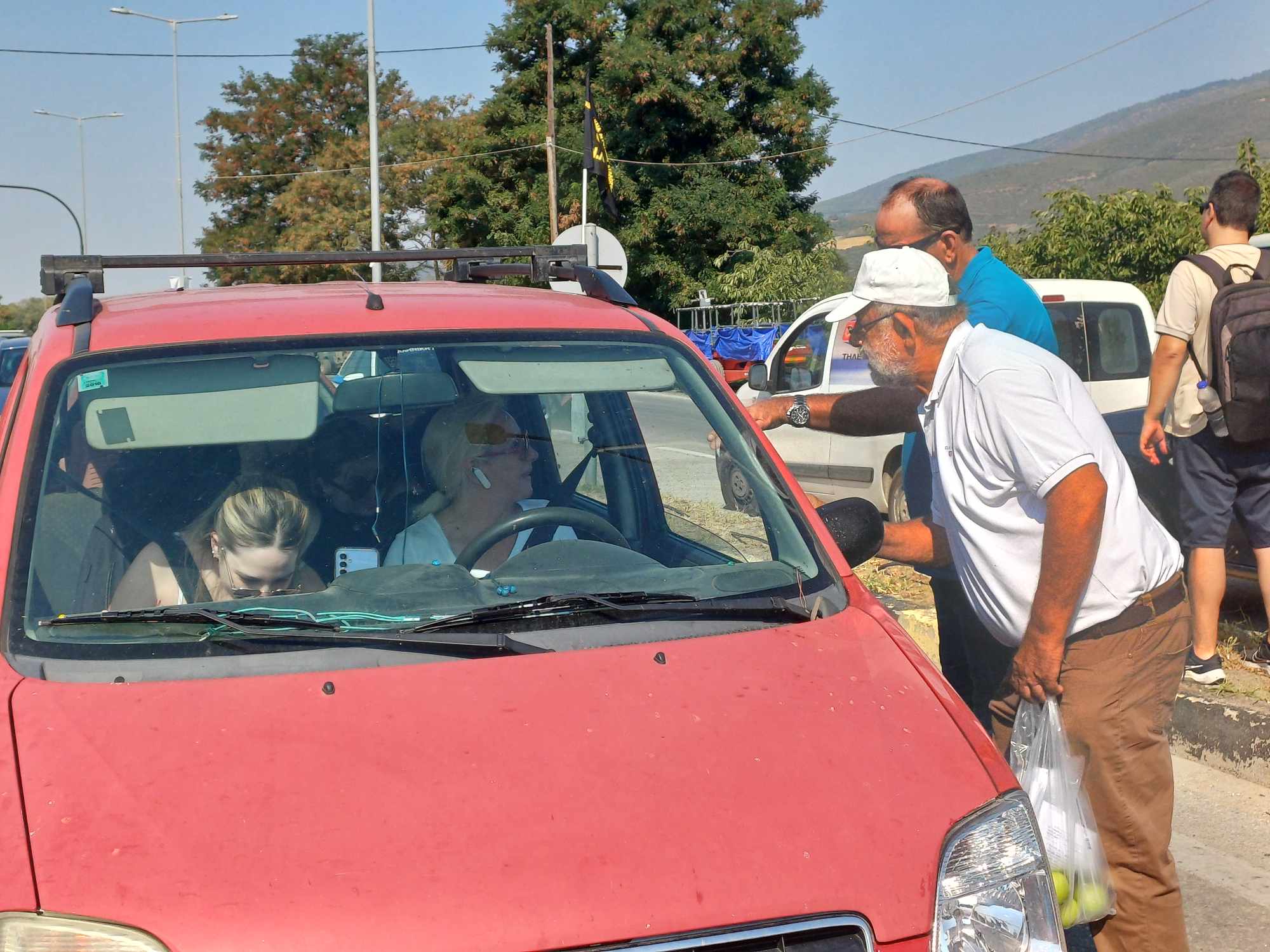 Εν μέσω καύσωνα έβγαλαν τρακτερ οι αγρότες στην είσοδο της Αγιάς και μοίρσαν μήλα στους επισκέπτες προς τα παράλια (ΦΩΤΟ+vide