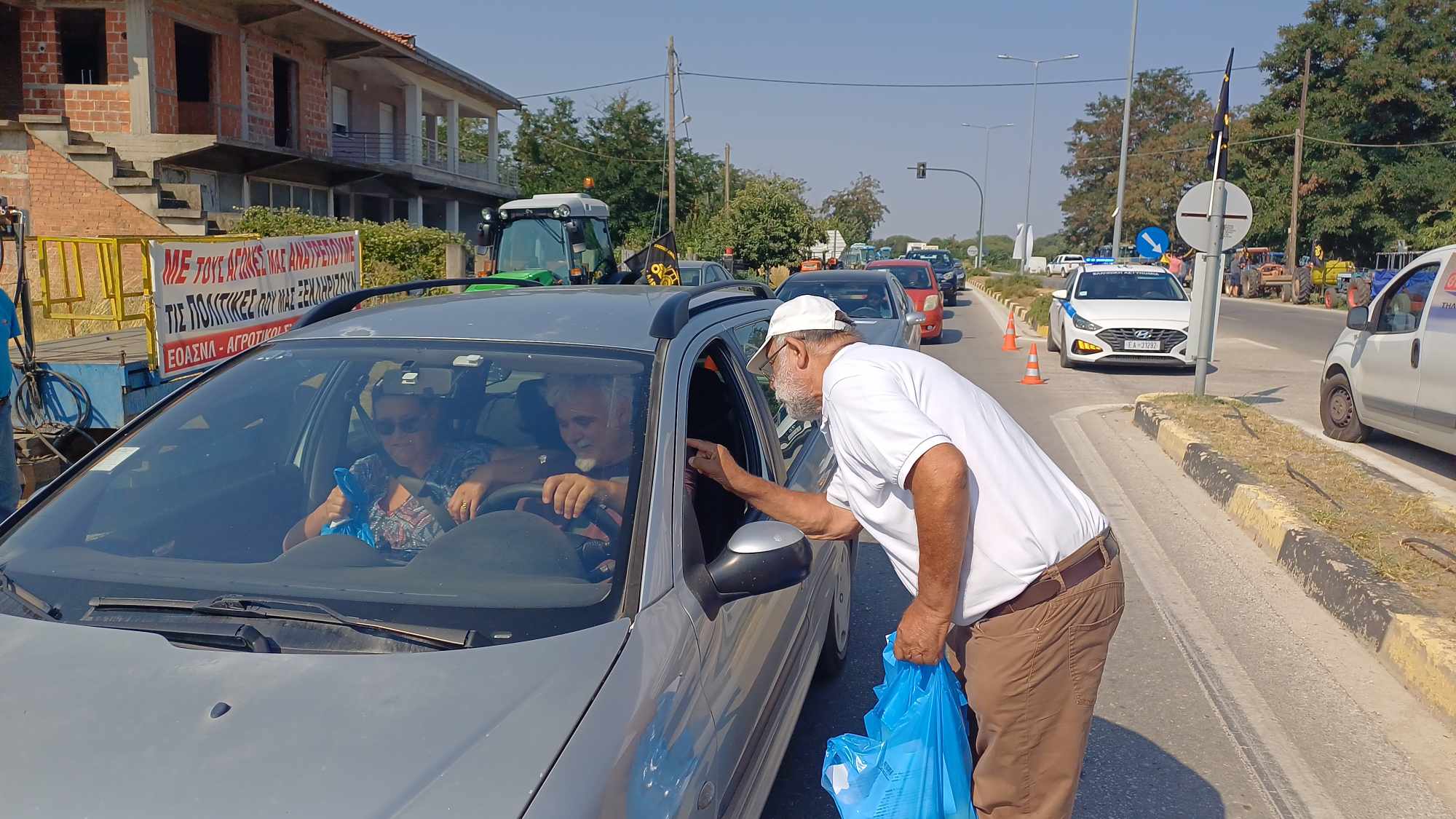 Εν μέσω καύσωνα έβγαλαν τρακτερ οι αγρότες στην είσοδο της Αγιάς και μοίρσαν μήλα στους επισκέπτες προς τα παράλια (ΦΩΤΟ+vide